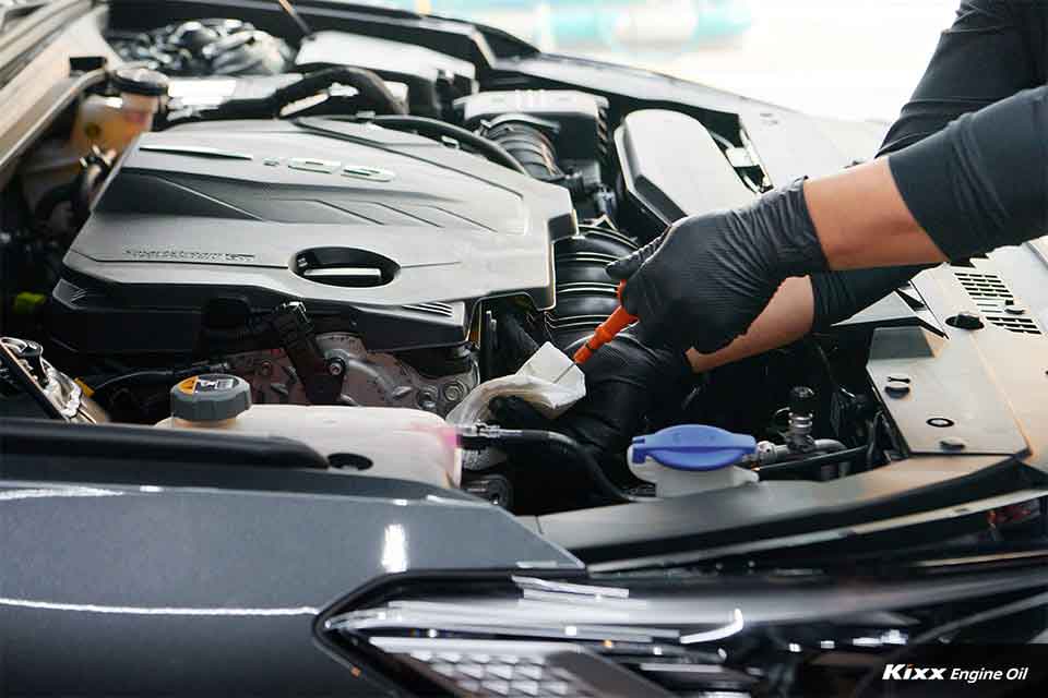 A close-up of a mechanic checking engine oil level