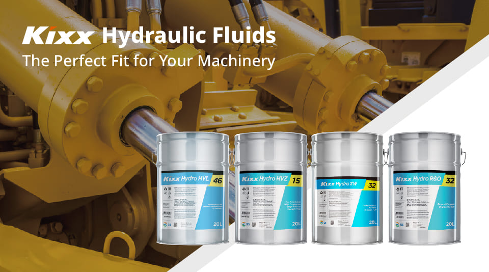 A shining yellow and chrome hydraulic system with four varieties of Kixx Hydraulic Fluid in the foreground in grey and blue drums.