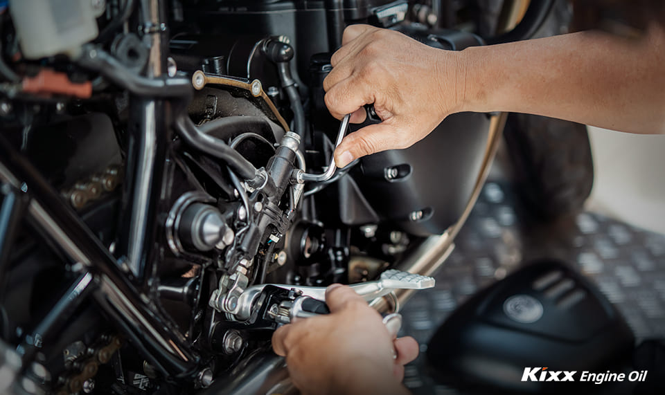 A mechanic leans in to inspect the parts of a bike